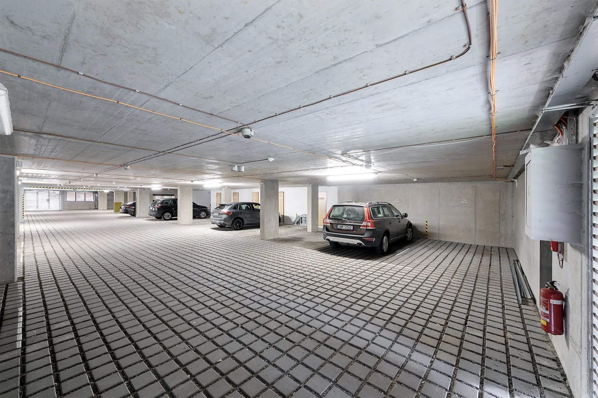 Obývací kuchyň apartmánu s krbem, dřevěnými trámy a jídelním stolem